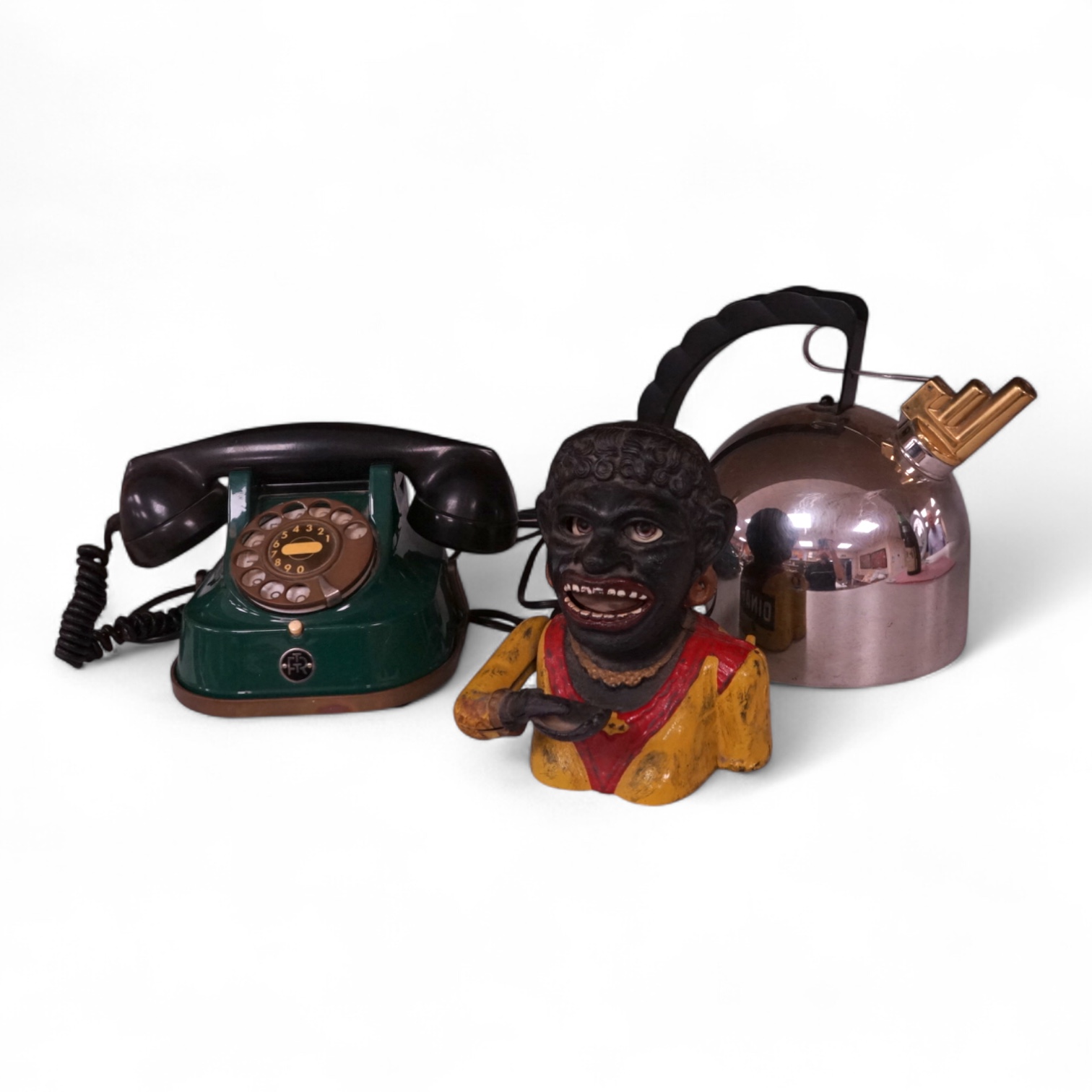 An Alessi 9091 kettle by Richard Sapper, an FTR green telephone and a painted cast iron mechanical money box. (3). Alessi kettle 22cm high.